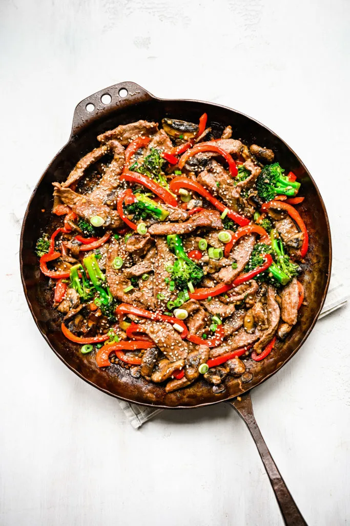 Beef and broccoli with garlic sauce in a metal pan.