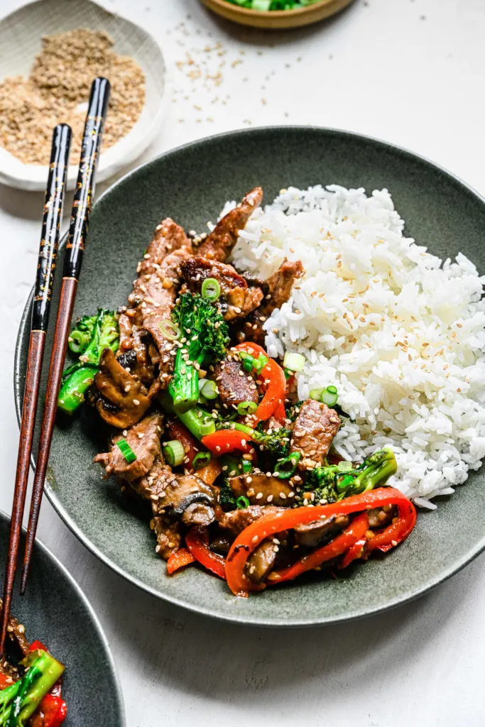 Close up view of beef with mushrooms and broccoli.