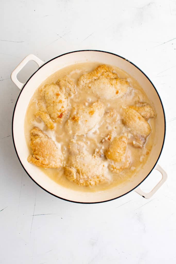 Chicken with lime coconut sauce cooking in a pan.