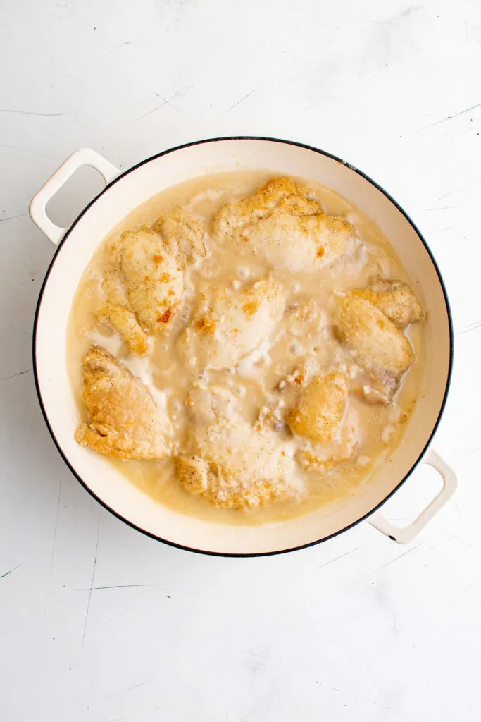 Chicken with lime coconut sauce cooking in a pan.