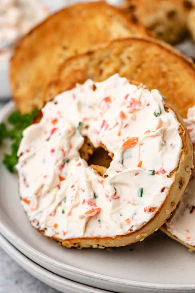 Close up view of an everything bagel with cream cheese.