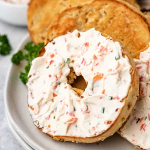 Cream cheese with veggies spread across a breakfast bagel.