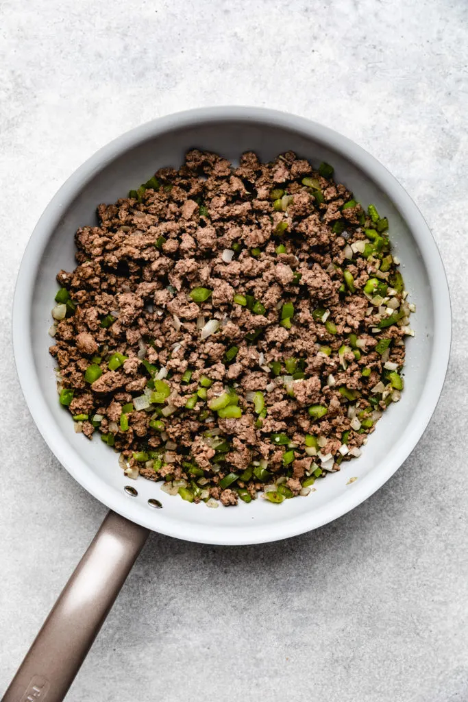 Cooked ground beef and onions in a skillet.