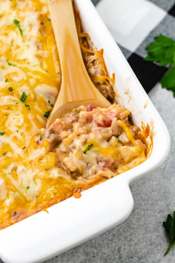 Spoon serving cheesy hamburger casserole.