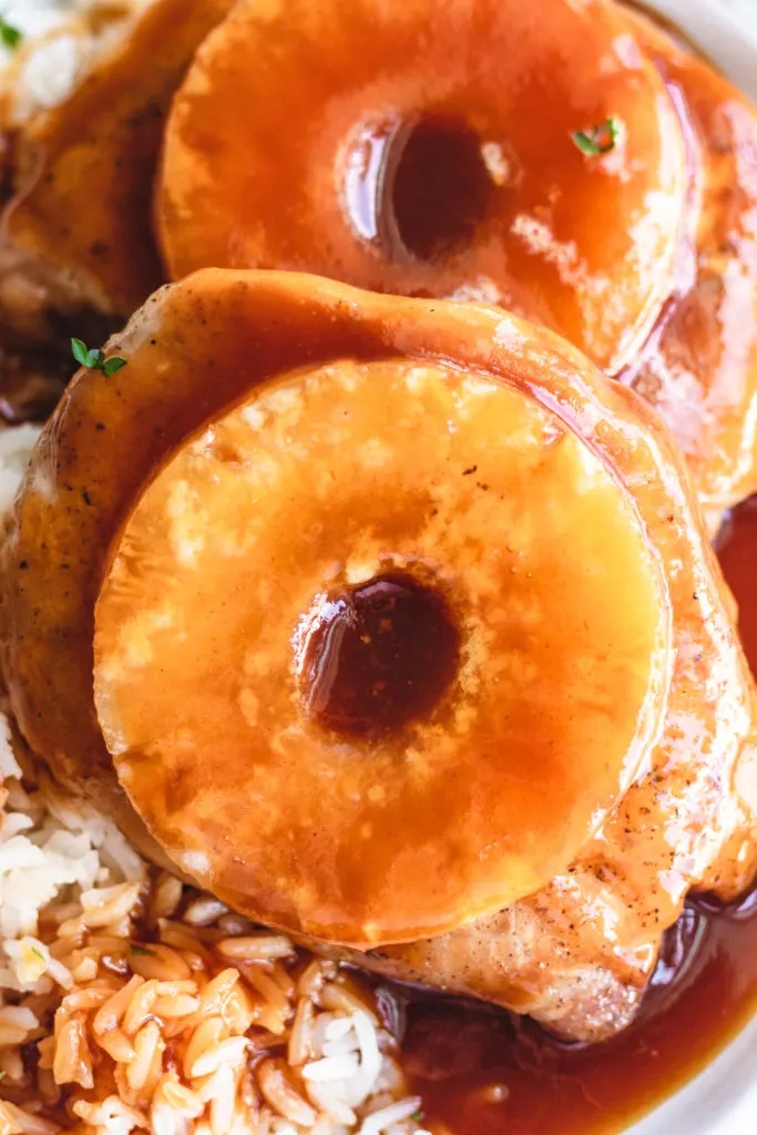 Close up view of baked pineapple pork chops on a plate.