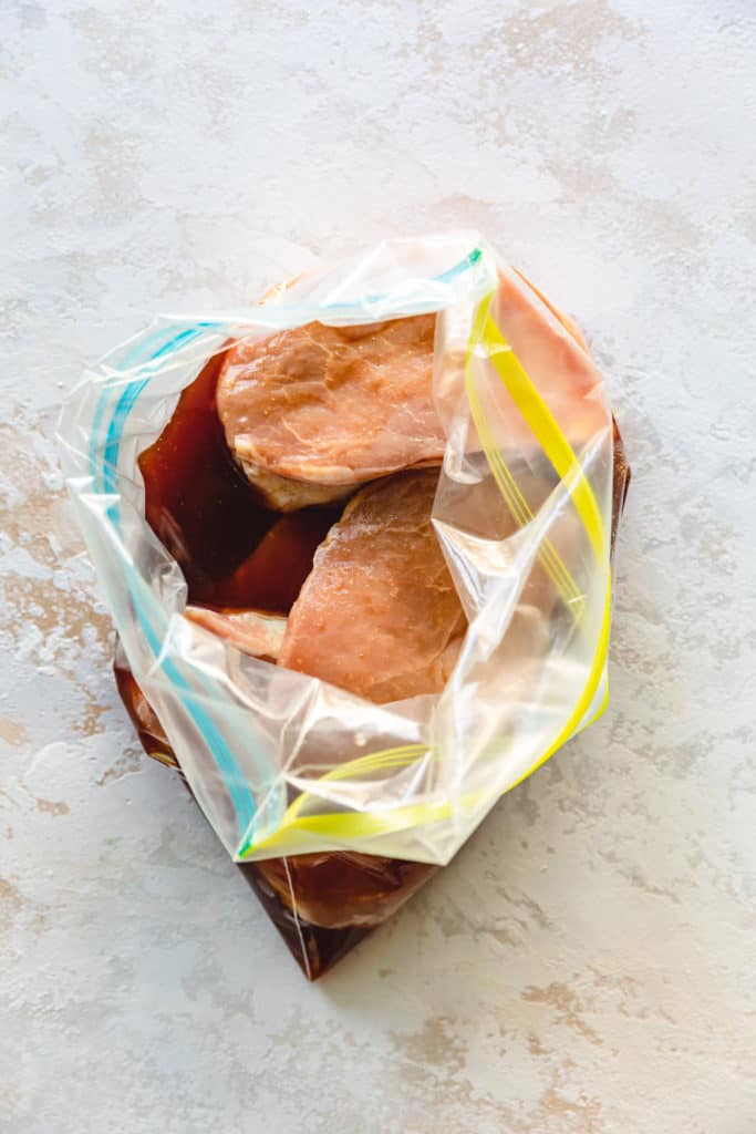 Pork chops in a plastic bag with marinade.
