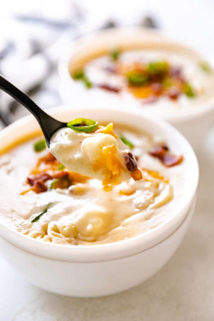 Bite of potato soup on a spoon.