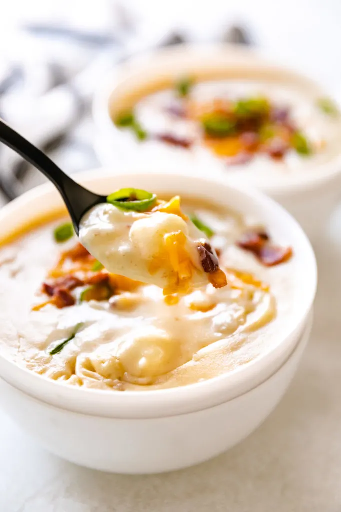 Bite of potato soup on a spoon.