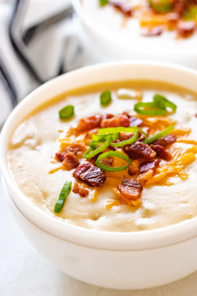 Thick potato cheese soup in a white bowl.