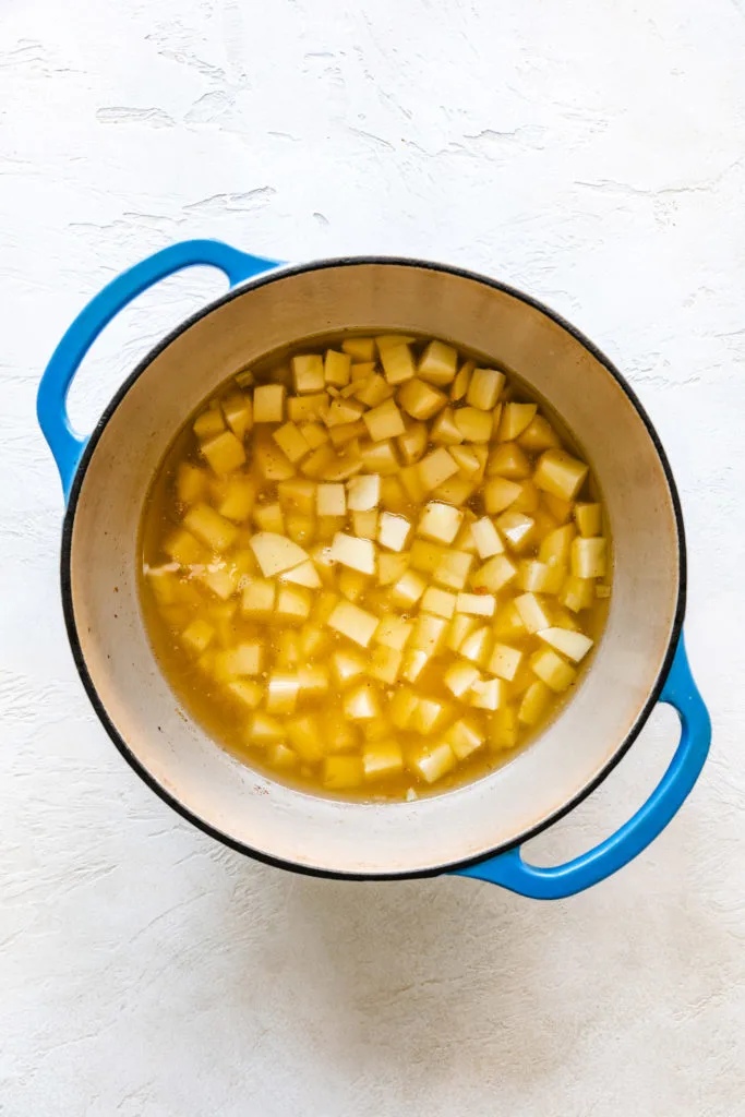 Potatoes in broth in a pan.