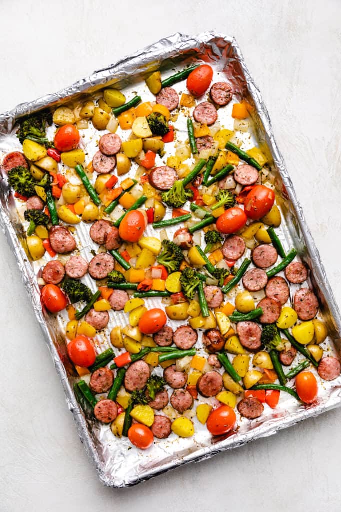 Tomatoes added to roasted vegetables and sausage.