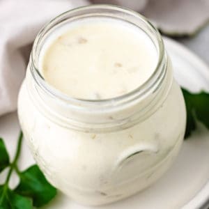 Close up view of a jar of green chile sour cream sauce.