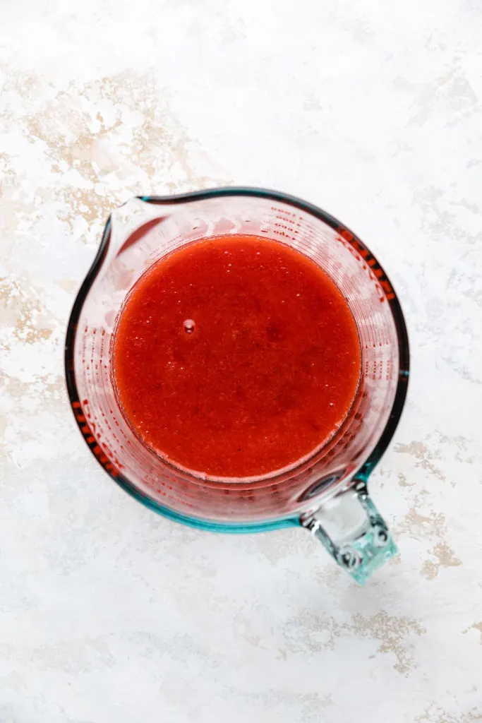 Strawberry glaze in a measuring cup.