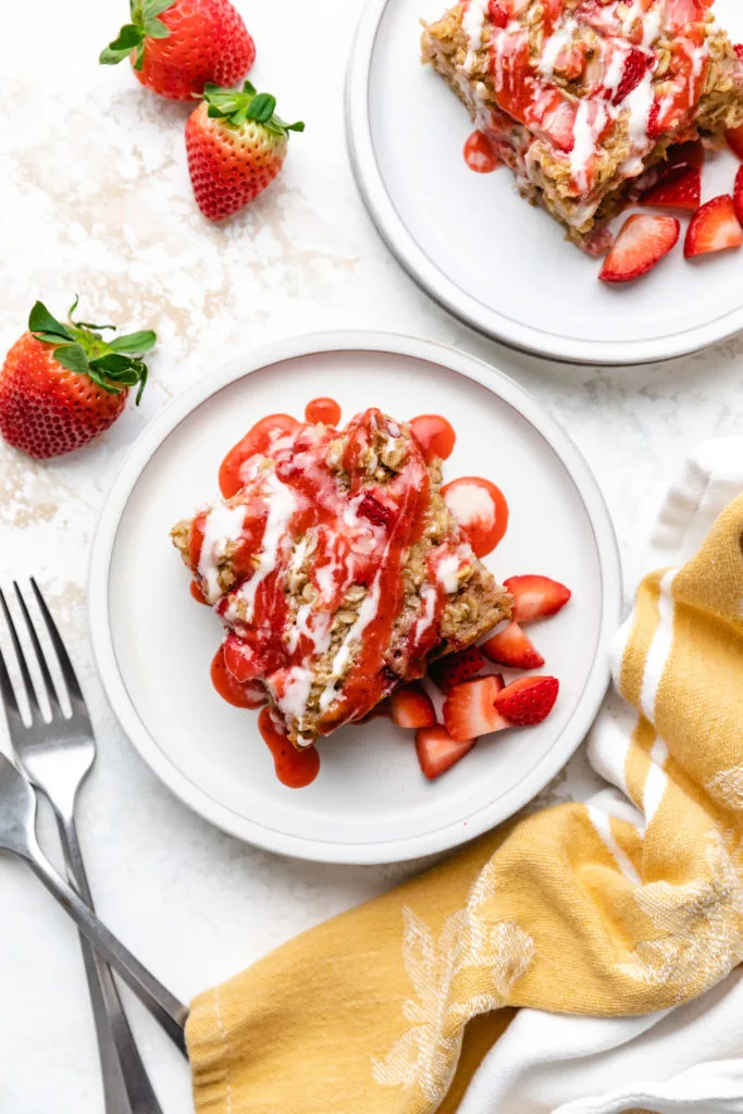 Top down view of baked oatmeal drizzled with vanilla and strawberry glaze.