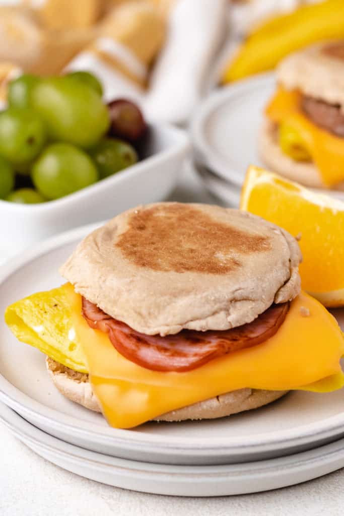 English muffin breakfast sandwich on plates.