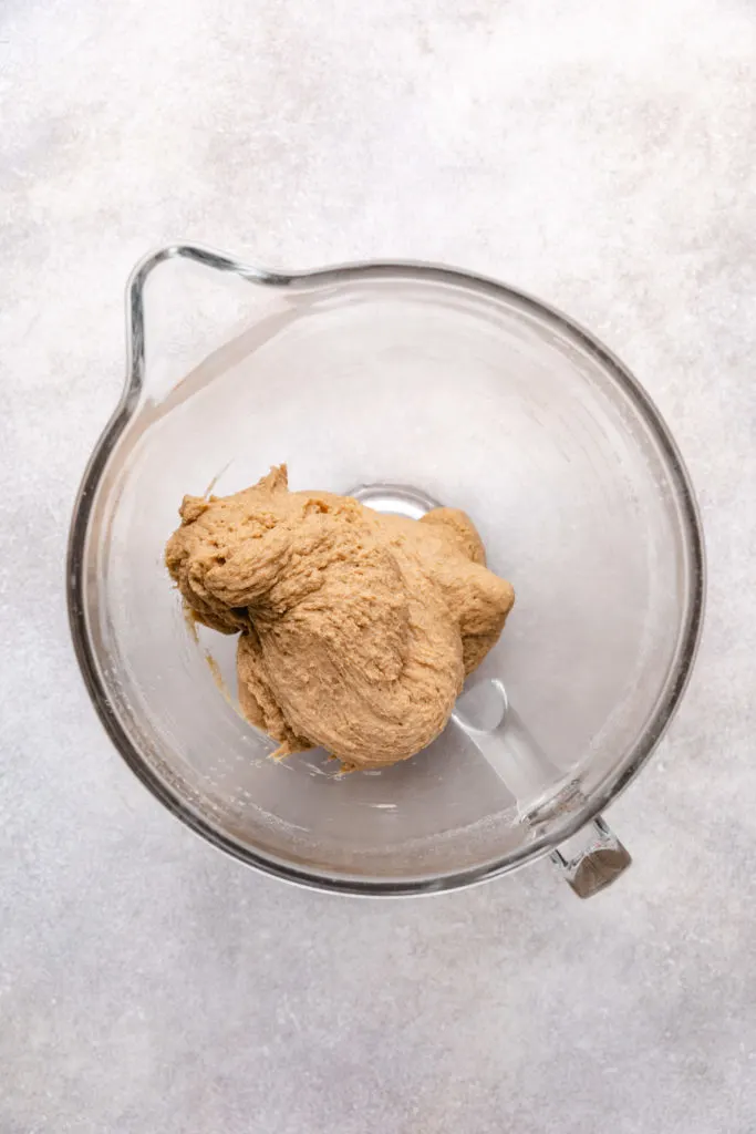 Wheat bread dough in a glass bowl.