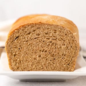 Side view of a loaf of honey wheat bread.