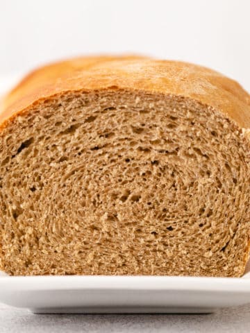 Side view of a loaf of honey wheat bread.