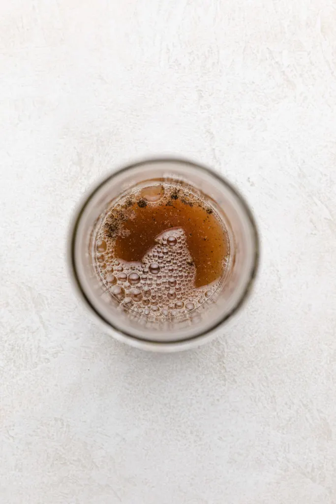 Top down view of honey and vinegar added to a jar.