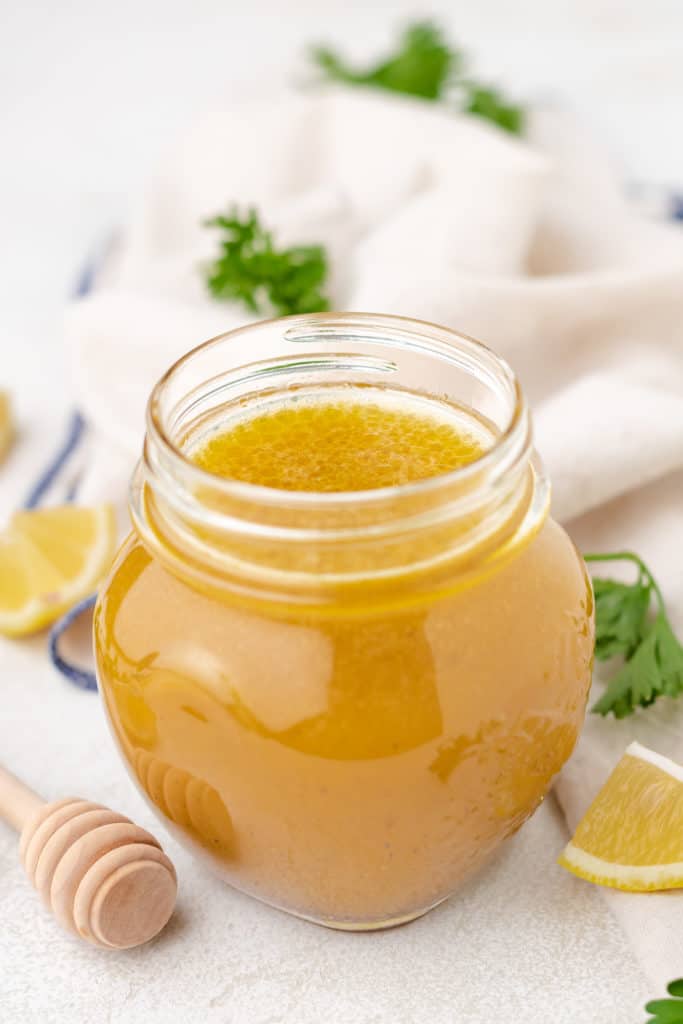 Side view of a jar of lemon dressing.