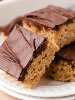 Close up view of rice krispie treats on a white plate.