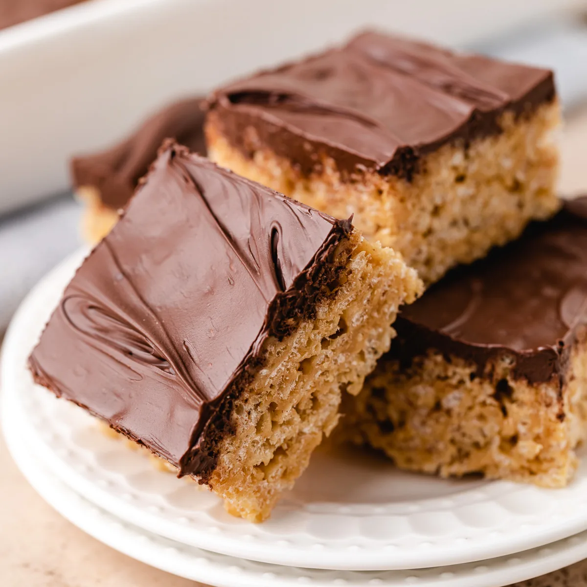 Close up view of rice krispie treats on a white plate.