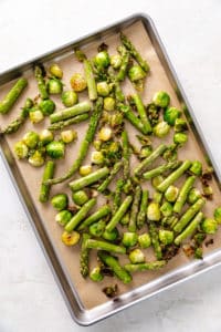 Asparagus and brussels sprouts on a pan.