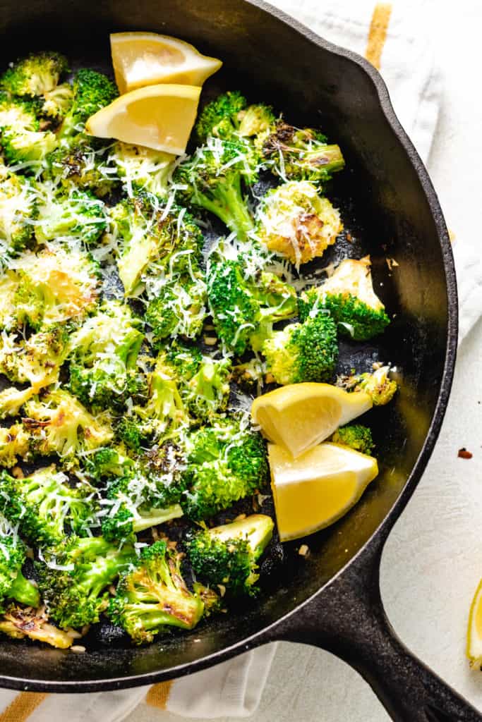 Lemon wedges in a pan of broccoli.