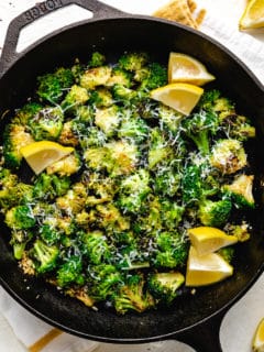 Top down view of a cast iron pan filled with sauteed broccoli.