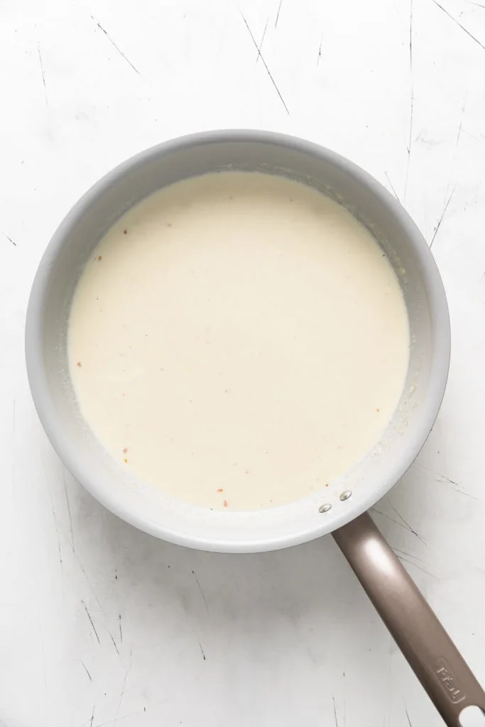 Milk and heavy cream poured into a pan of butter and flour.