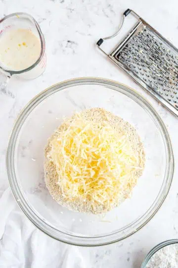 Grated butter on top of flour scone ingredients.