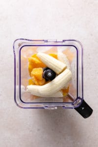 Banana, frozen mango, and milk in a blender.