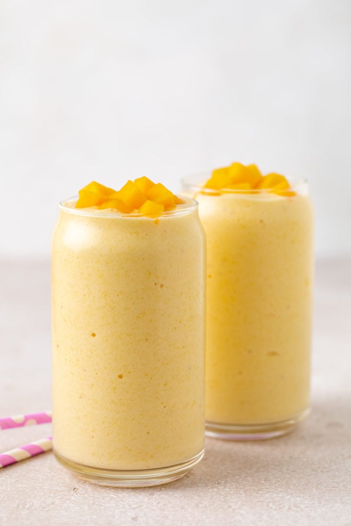 Side view of a mango banana smoothie in a glass.