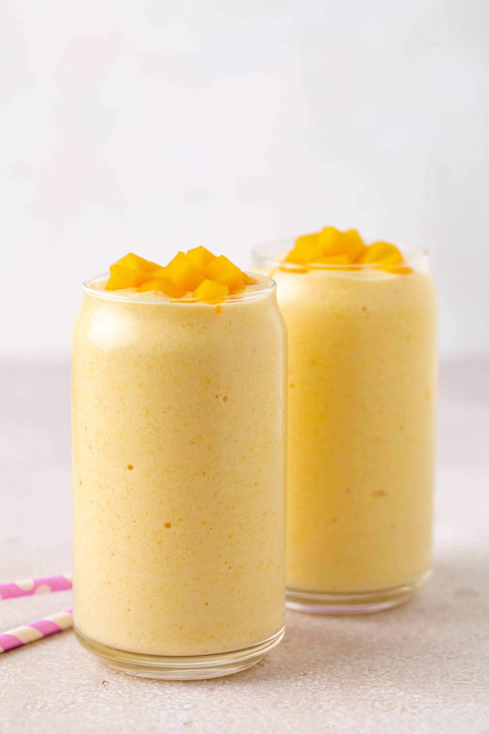 Side view of a mango banana smoothie in a glass.