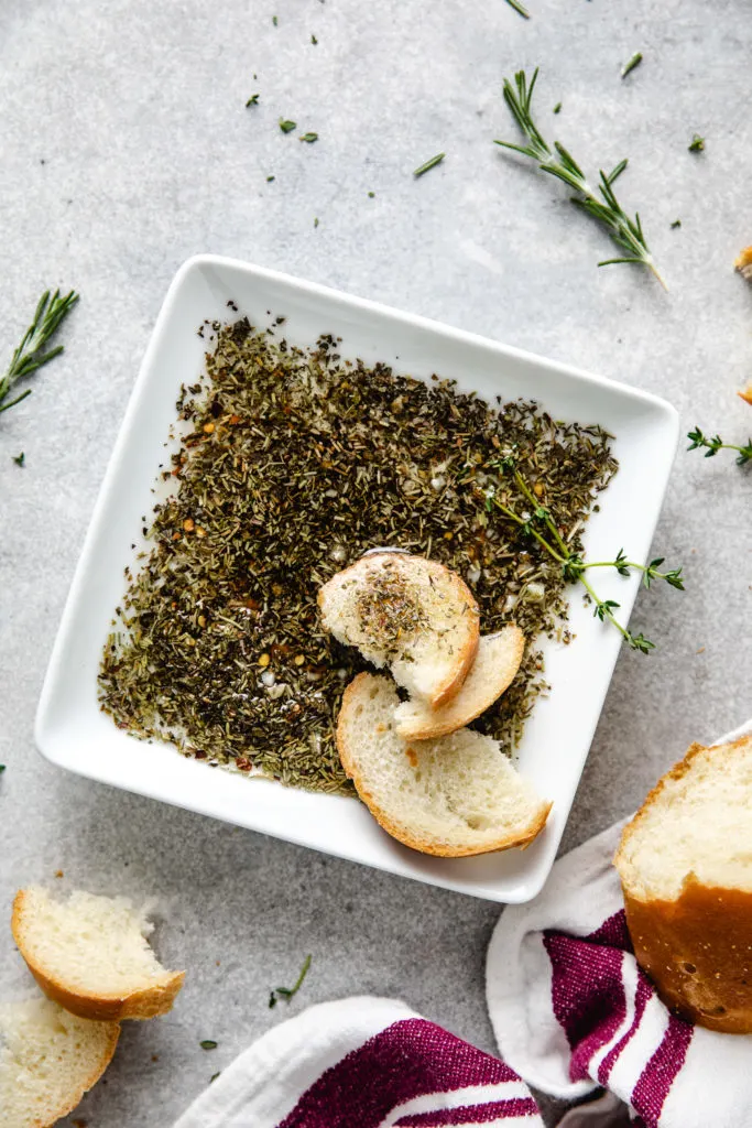 Pieces of bread in dish of dipping oil.