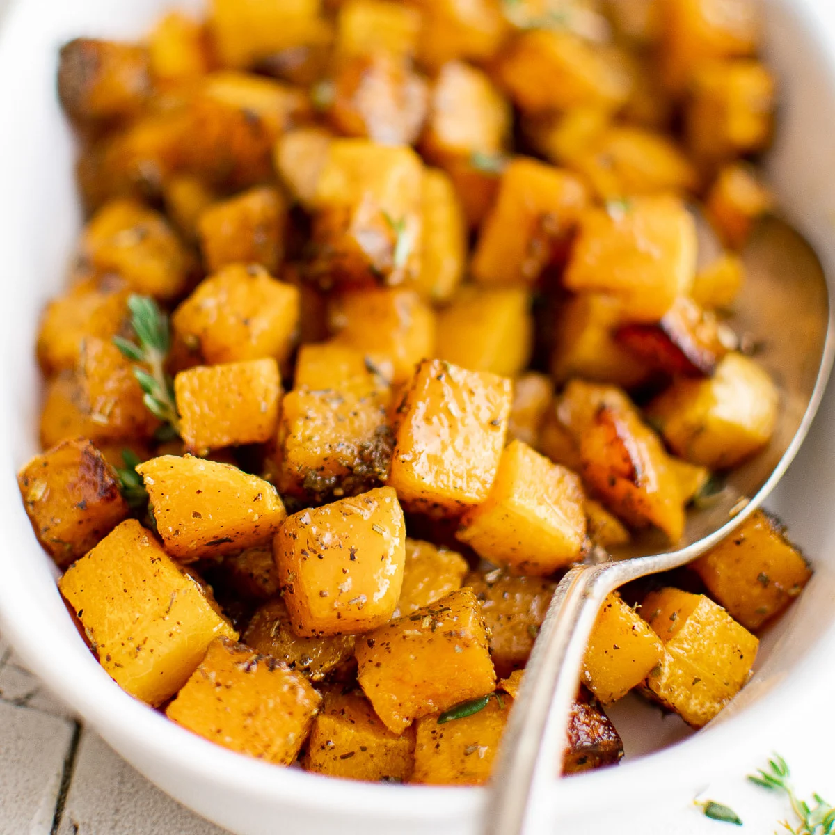 Side view of roasted butternut squash in a serving dish.