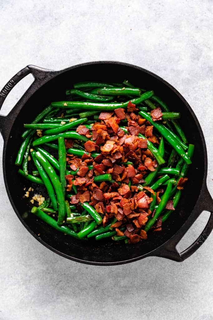 Bacon, beans and garlic in a pan.