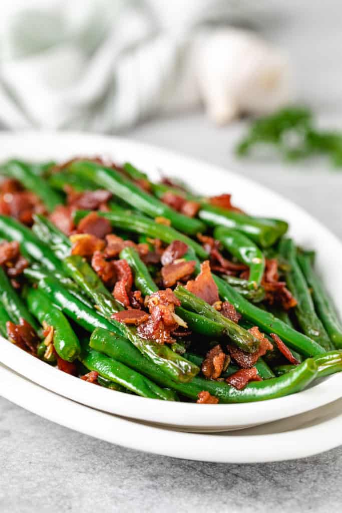 Close up view of beans topped with crispy bacon.