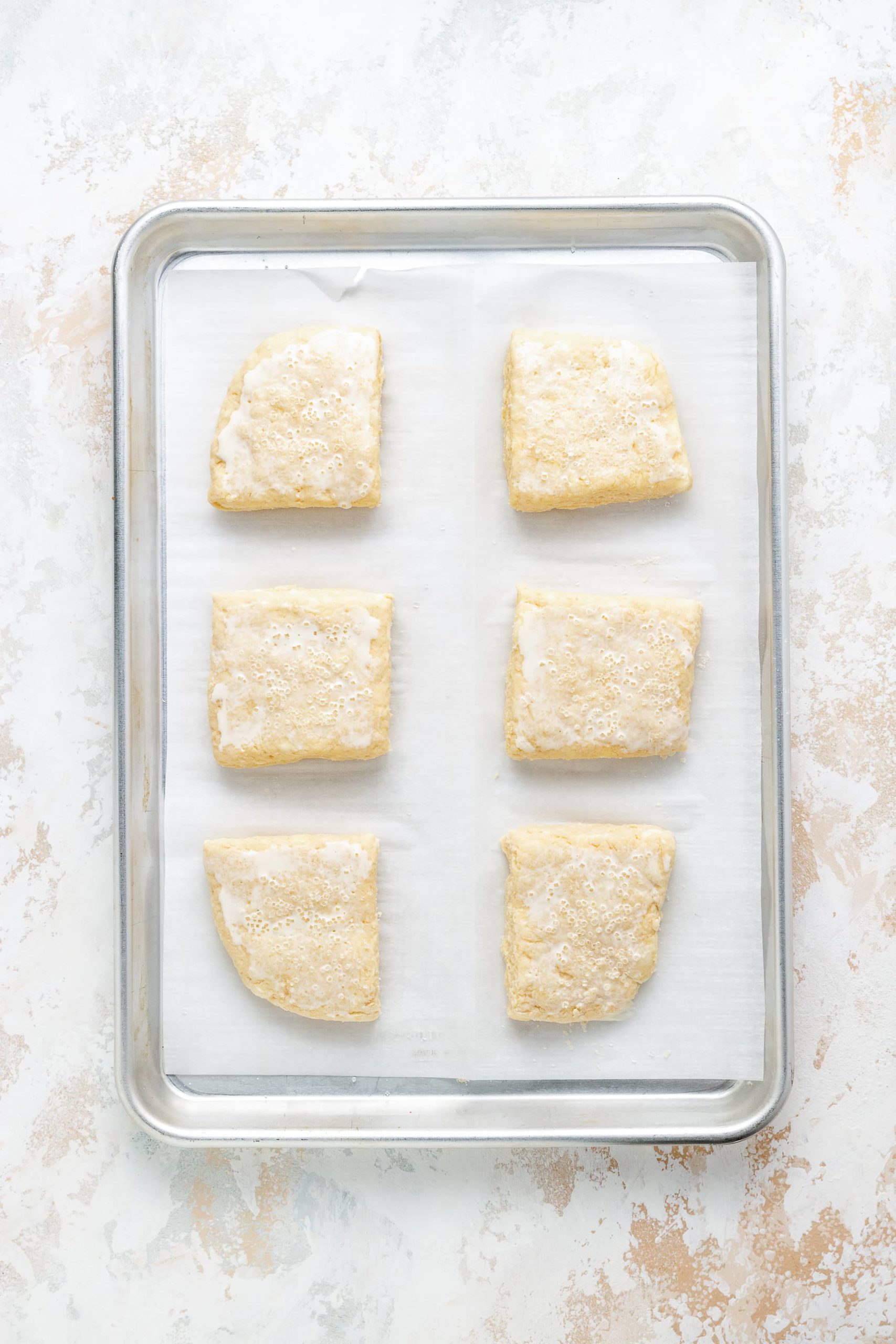 Unbaked shortcake biscuits with heavy cream and sugar.