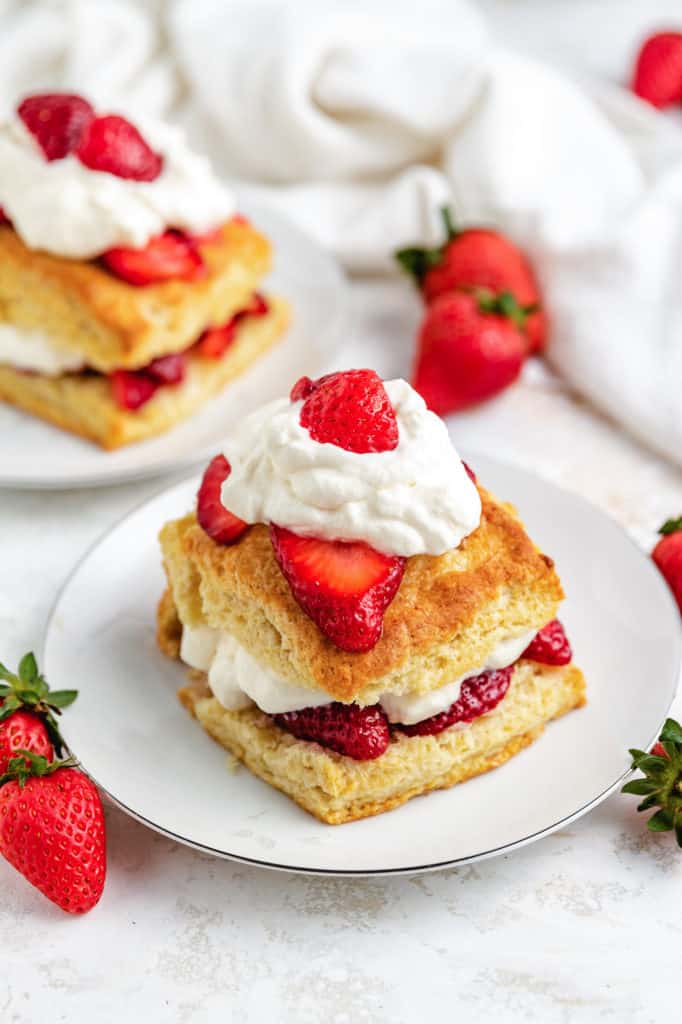 Angled view of shortcakes with strawberries on a plates.