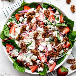 Close up view of a salad with strawberry slices.