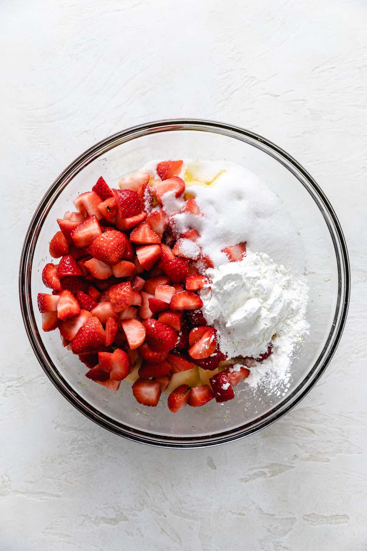 Sugar, cornstarch, lemon juice, strawberries, and apples in a large bowl.