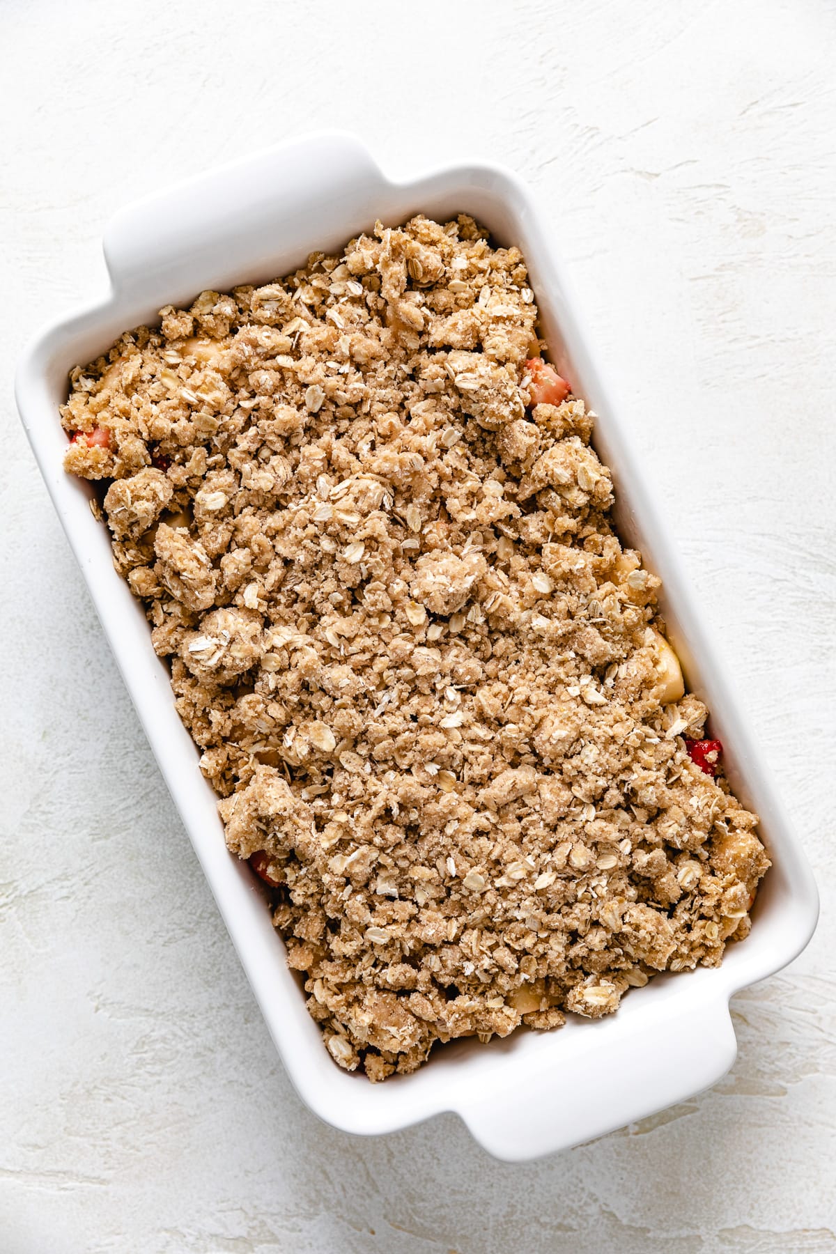 Unbaked fruit crisp in a casserole dish.