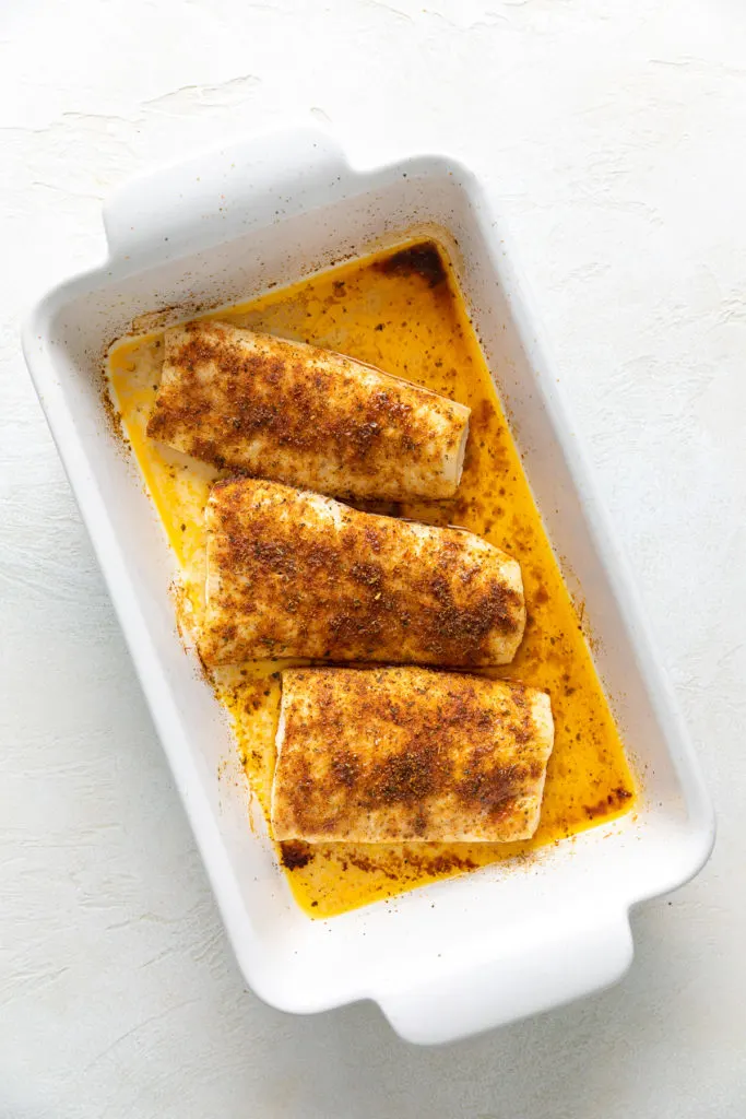 Seasoned baked mahi in a casserole dish.