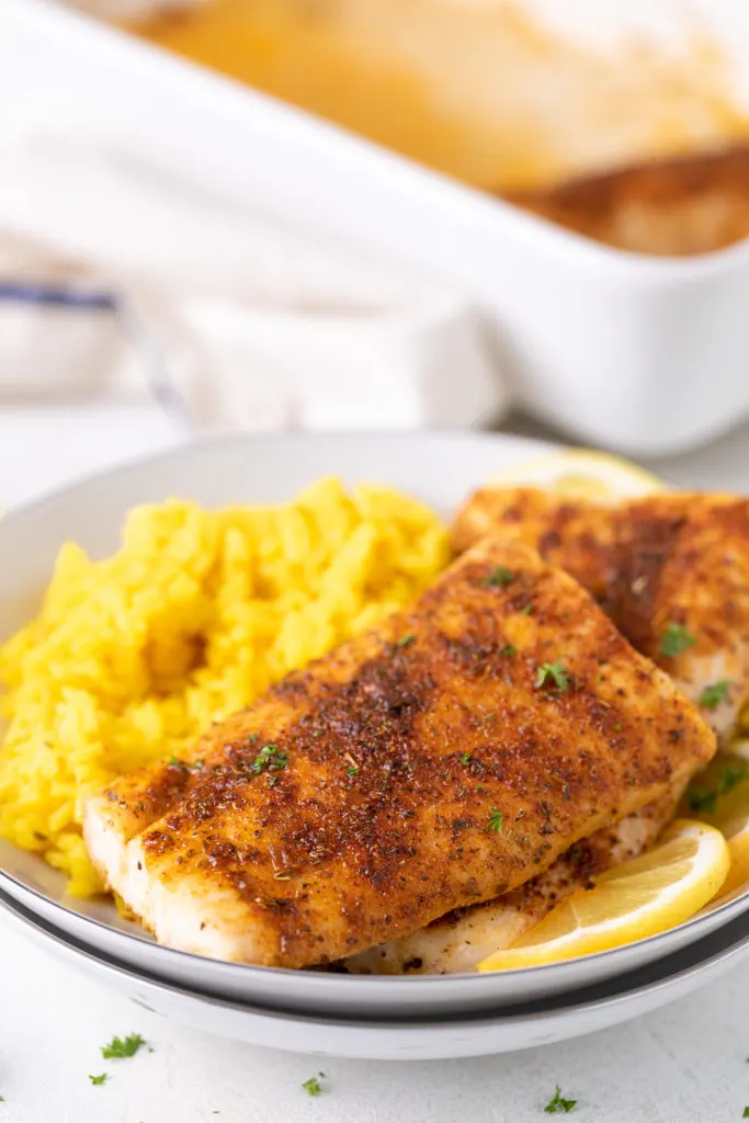 Seasoned fish filets on a plate.