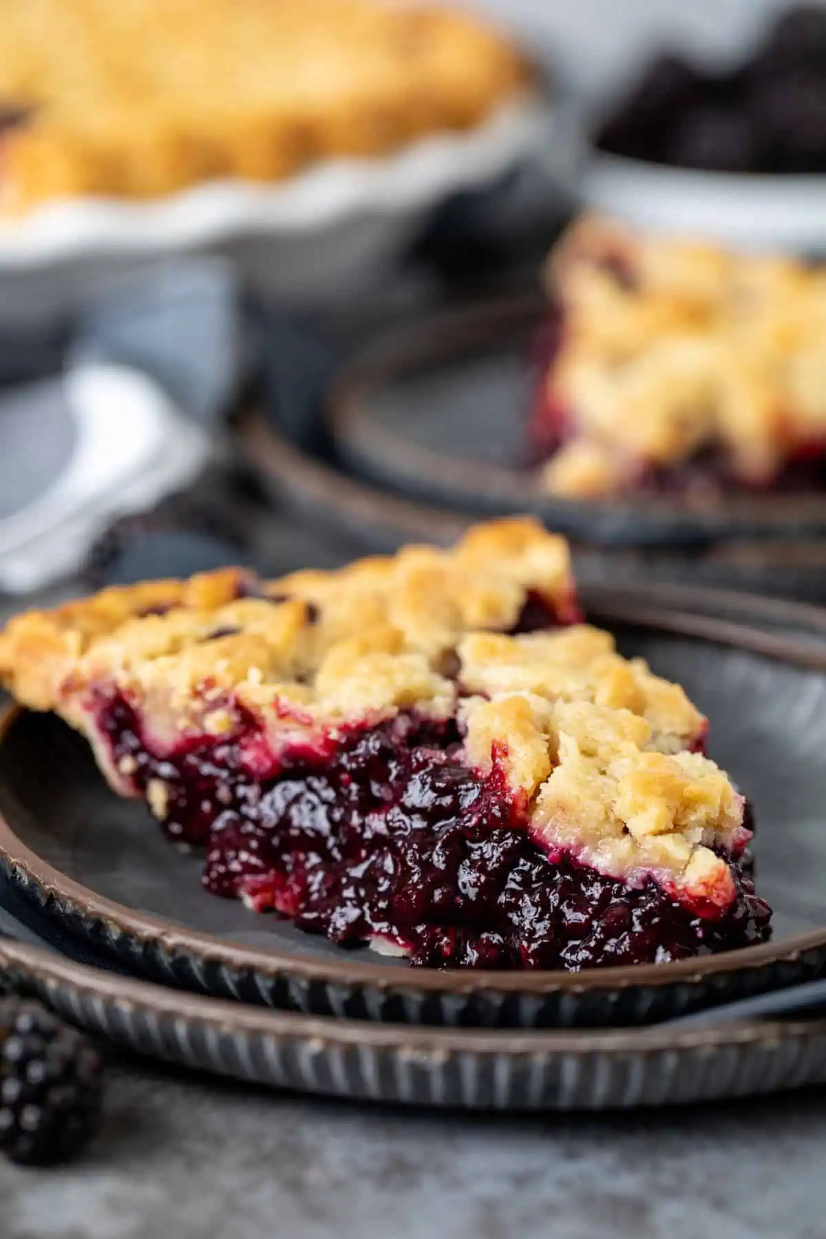 Close up view of a slice of pie on a stack of plates.