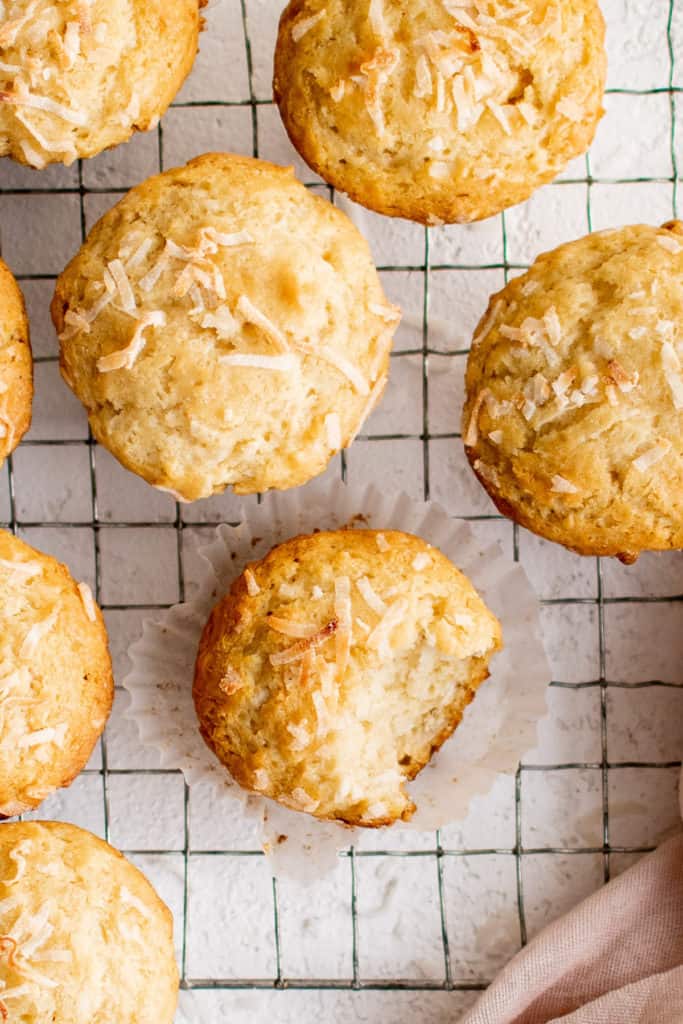 Coconut muffins on a wire rack.
