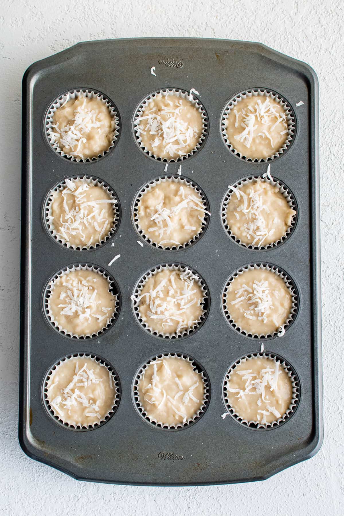 Unbaked muffins in a pan.