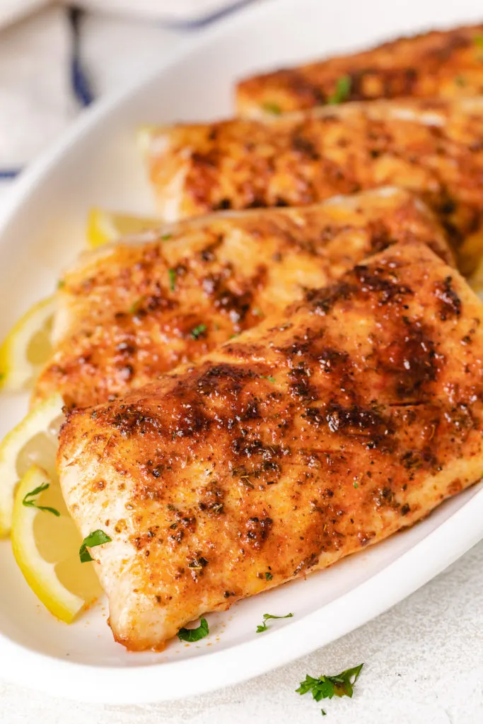 Filets of mahi mahi on a white serving dish.