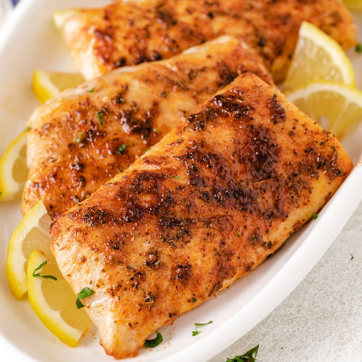 Close up view of fish on a large white plate.